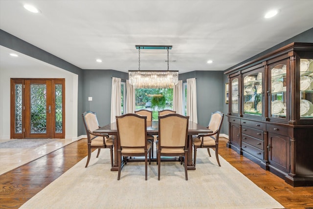 dining room featuring an inviting chandelier, recessed lighting, baseboards, and wood finished floors