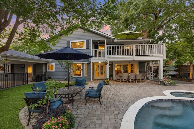 back of property with outdoor lounge area, fence, a patio, french doors, and an in ground hot tub