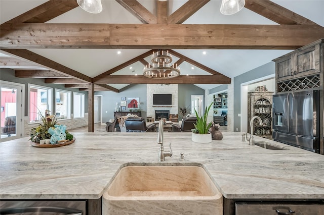 15062 Lake Paula Dr, Willis, TX 77318 - kitchen featuring a sink, lofted ceiling with beams, stainless steel appliances, and open floor plan