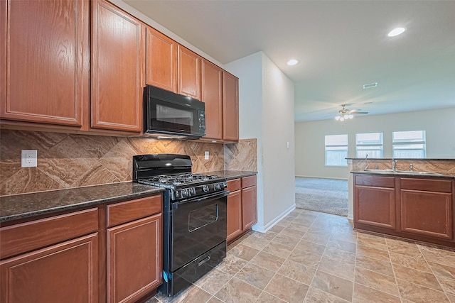 kitchen with ceiling fan, backsplash, baseboards, black appliances, and dark stone countertops
