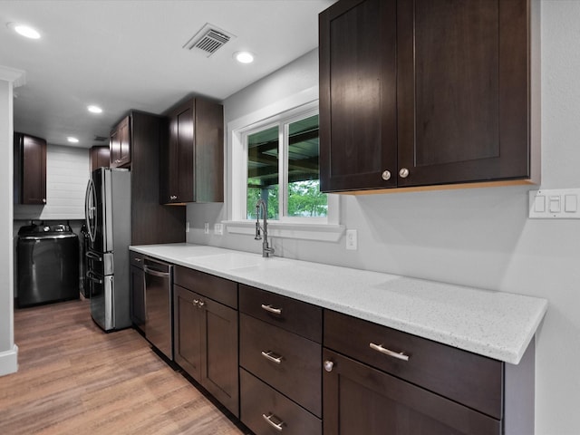 14800 Tallow St, Santa Fe, TX 77517 - kitchen featuring visible vents, light wood-type flooring, a sink, washer / dryer, and stainless steel appliances