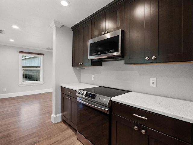 14800 Tallow St, Santa Fe, TX 77517 - kitchen featuring dark brown cabinetry, crown molding, appliances with stainless steel finishes, baseboards, and light wood-style floors