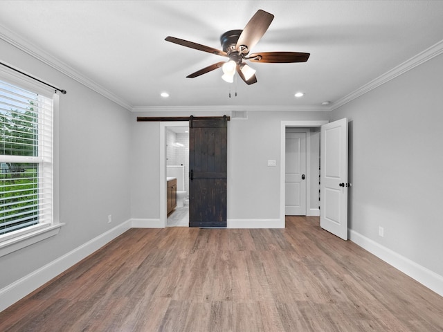 14800 Tallow St, Santa Fe, TX 77517 - unfurnished bedroom featuring a barn door, recessed lighting, baseboards, wood finished floors, and ornamental molding