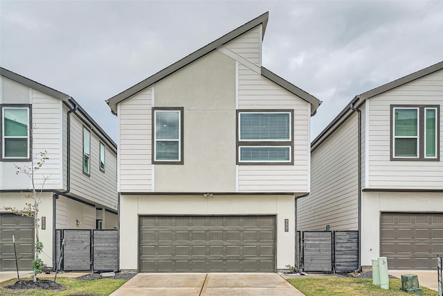 view of front of home featuring stucco siding, a garage, fence, and concrete driveway