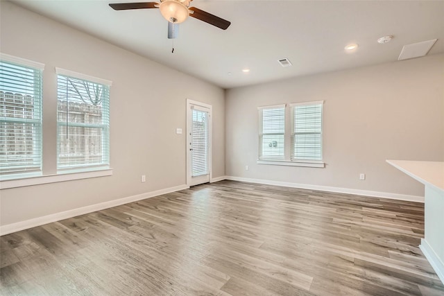 unfurnished living room featuring ceiling fan, visible vents, wood finished floors, baseboards, and recessed lighting