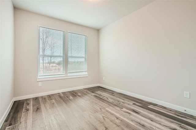 empty room featuring baseboards and wood finished floors