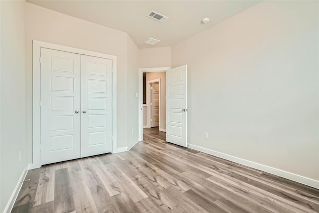 unfurnished bedroom with visible vents, baseboards, and light wood-type flooring