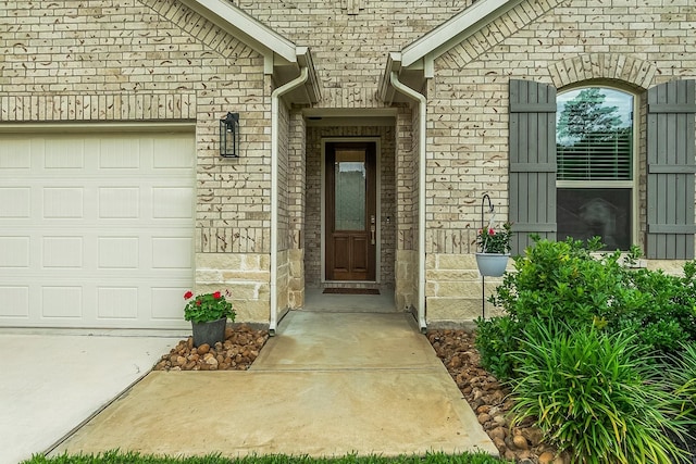 entrance to property featuring brick siding, stone siding, and a garage