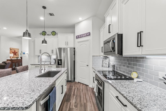 kitchen featuring white cabinets, dark wood-style flooring, a sink, a kitchen island with sink, and stainless steel appliances