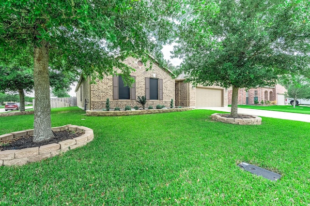 obstructed view of property featuring a garage, fence, a front yard, brick siding, and driveway