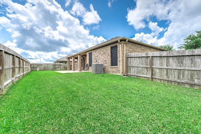 view of yard featuring a patio, a fenced backyard, and central AC
