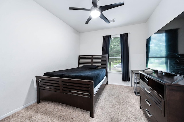 bedroom featuring baseboards, a ceiling fan, visible vents, and light carpet