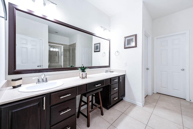 full bath featuring double vanity, a sink, tile patterned flooring, and a shower stall