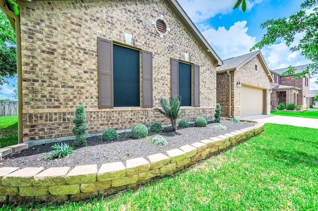 view of front of property featuring brick siding, an attached garage, a front yard, and concrete driveway