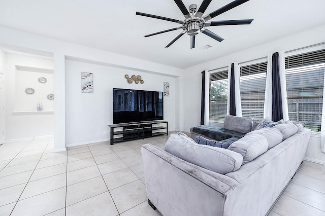living room featuring light tile patterned flooring, ceiling fan, visible vents, and baseboards