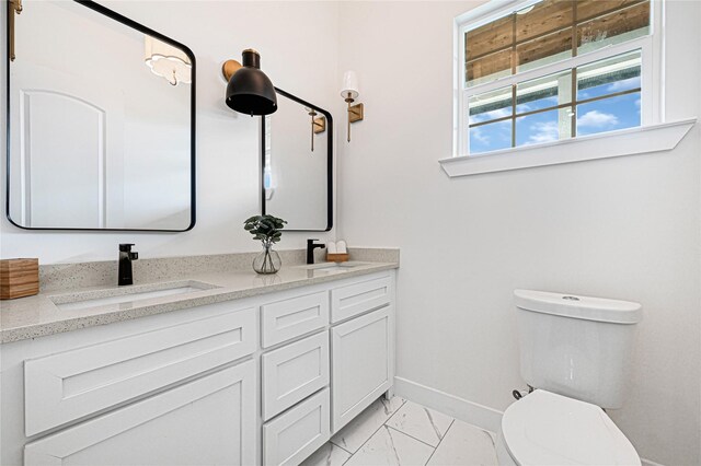 203 Dwire Dr, La Porte, TX 77571 - bathroom with double vanity, marble finish floor, toilet, baseboards, and a sink