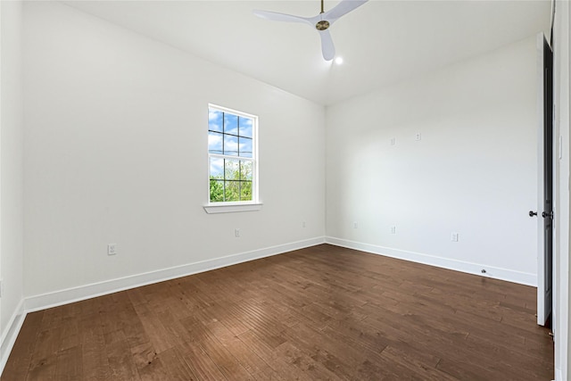 spare room with baseboards, a ceiling fan, and dark wood finished floors