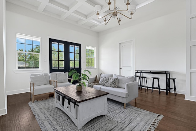 living area featuring beam ceiling, baseboards, a notable chandelier, coffered ceiling, and dark wood-type flooring