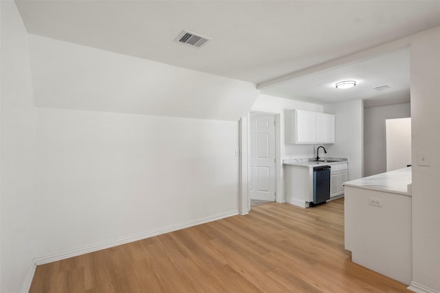 7817 Woodlyn Rd, Houston, TX 77028 - kitchen featuring light wood-type flooring, dishwasher, light countertops, white cabinetry, and baseboards