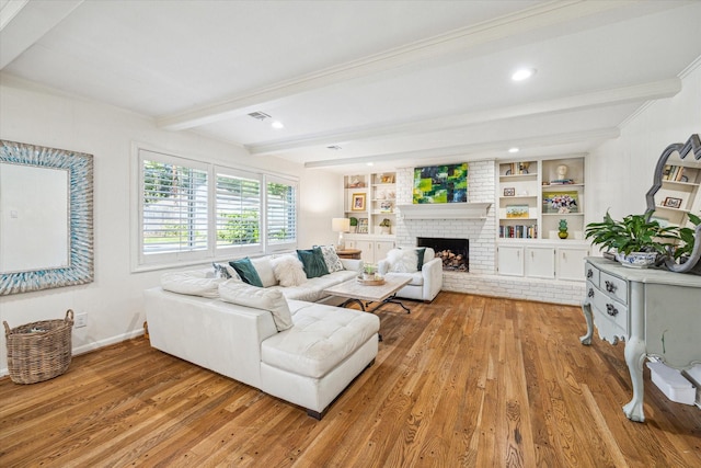 living area featuring baseboards, beamed ceiling, a brick fireplace, and light wood finished floors