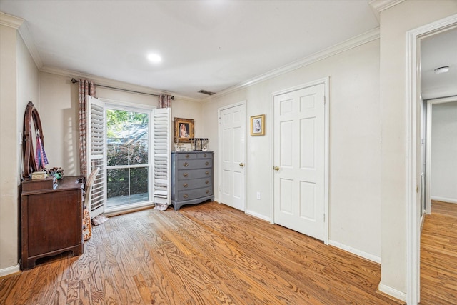 bedroom featuring crown molding, baseboards, visible vents, and light wood-style floors
