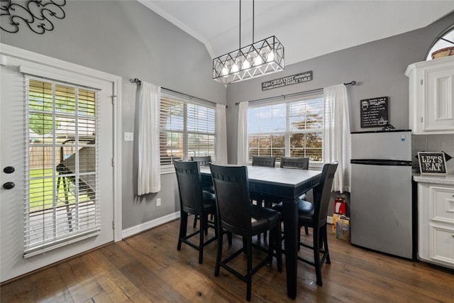 dining area with baseboards, ornamental molding, dark wood finished floors, and lofted ceiling