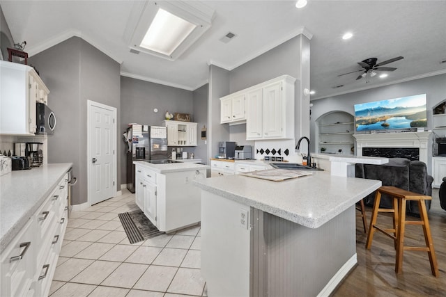 kitchen with ceiling fan, a sink, a peninsula, open floor plan, and visible vents