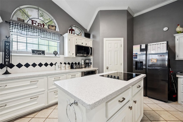 kitchen with a kitchen island, white cabinetry, tasteful backsplash, light tile patterned floors, and stainless steel appliances