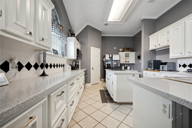 kitchen featuring light tile patterned floors, a center island, decorative backsplash, and white cabinets
