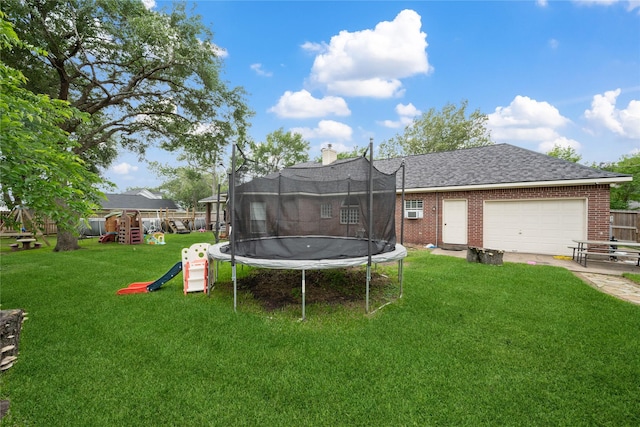 rear view of property featuring a lawn, a trampoline, a playground, and brick siding