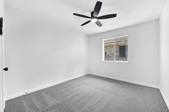 carpeted spare room featuring baseboards and ceiling fan