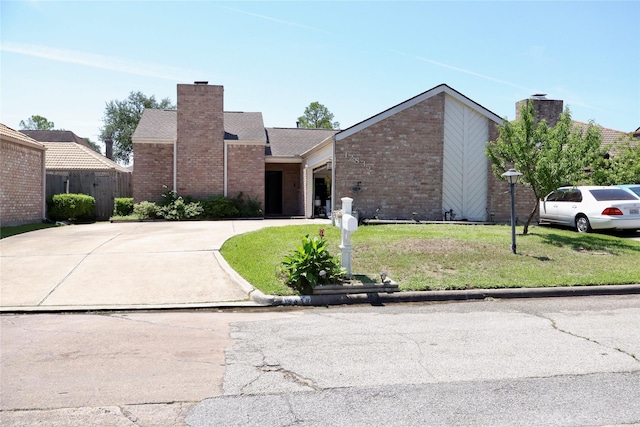 12835 Ashford Chase Dr, Houston, TX 77082 - view of front of house featuring a chimney, driveway, a front lawn, and brick siding