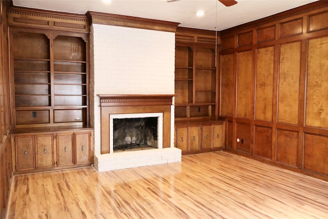 12835 Ashford Chase Dr, Houston, TX 77082 - unfurnished living room featuring light wood-type flooring, ceiling fan, built in shelves, and a fireplace