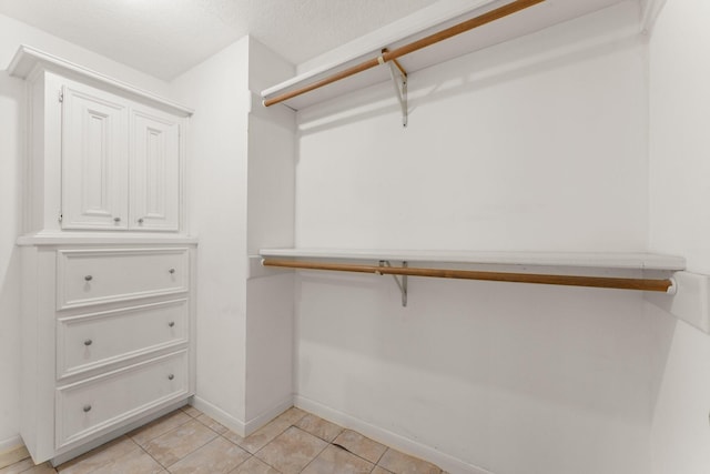 spacious closet with light tile patterned floors
