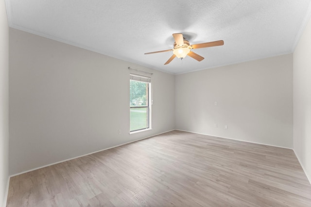 spare room featuring crown molding, light wood-style floors, baseboards, ceiling fan, and a textured ceiling