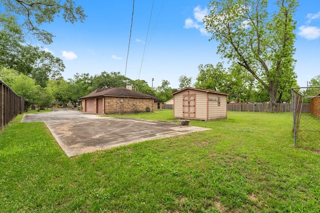view of yard featuring fence, an outbuilding, a shed, and a garage