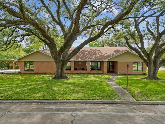 view of front of home with brick siding and a front yard