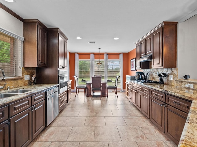 kitchen with appliances with stainless steel finishes, a sink, decorative backsplash, recessed lighting, and dark brown cabinets