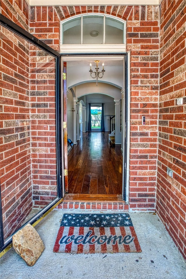 view of exterior entry featuring brick siding