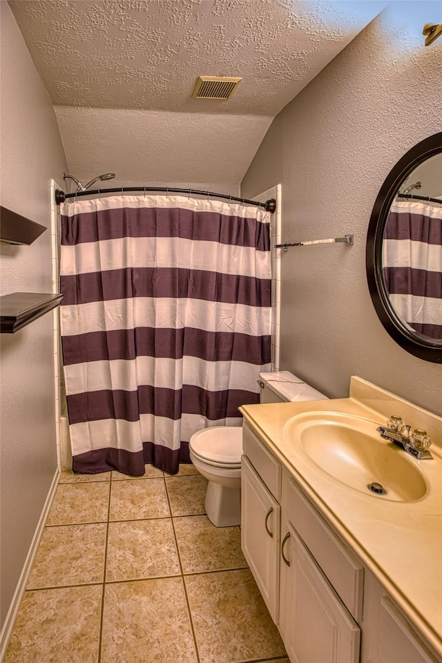 bathroom with lofted ceiling, a textured ceiling, toilet, vanity, and tile patterned floors