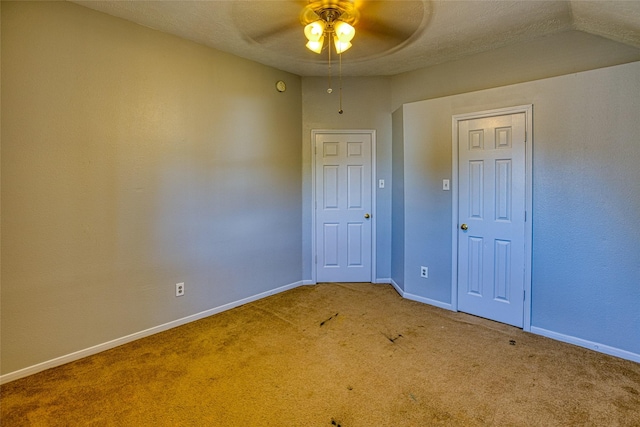carpeted spare room with ceiling fan and baseboards