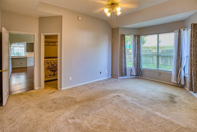 carpeted spare room with a ceiling fan, baseboards, and a sink