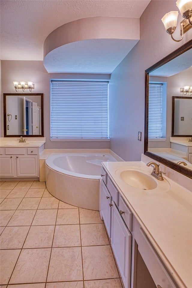 bathroom with a bath, tile patterned floors, two vanities, and a chandelier