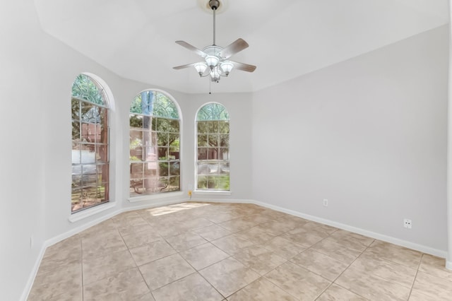 spare room with baseboards, a ceiling fan, lofted ceiling, and light tile patterned floors