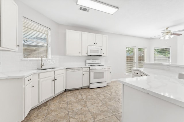 kitchen with a ceiling fan, visible vents, a sink, white cabinets, and white appliances