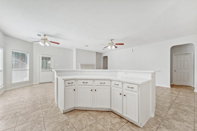 kitchen featuring light tile patterned floors, arched walkways, and a ceiling fan