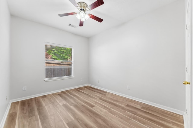 empty room featuring a ceiling fan, baseboards, visible vents, and light wood finished floors