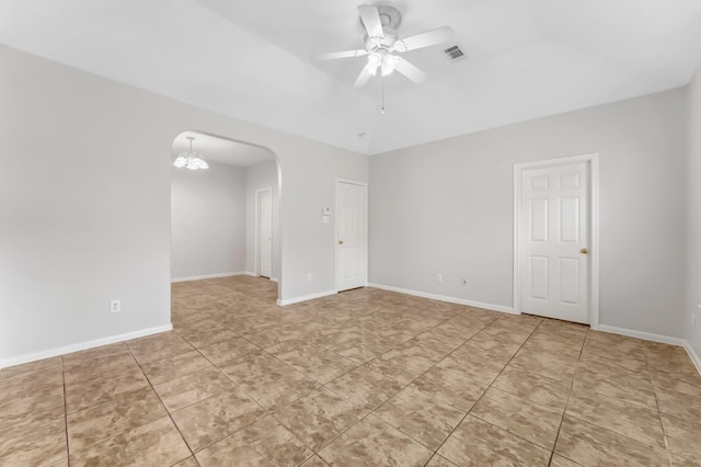 tiled empty room featuring visible vents, arched walkways, and a ceiling fan