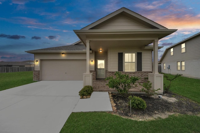 view of front of home featuring brick siding, a garage, a lawn, and concrete driveway