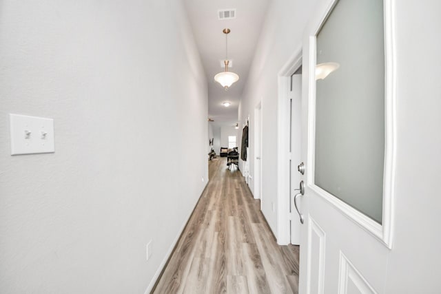 hallway with visible vents and light wood-type flooring